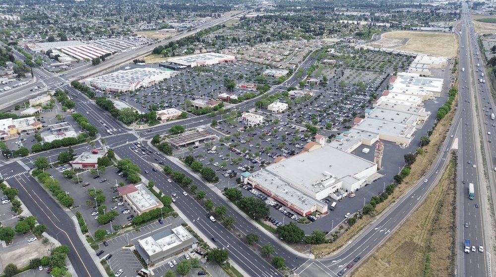 Aerial view of Monte Vista Crossings shopping center with clock tower along Highway 99